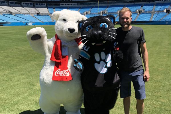 zach with sir purr and coca cola polar bear on carolina panthers field